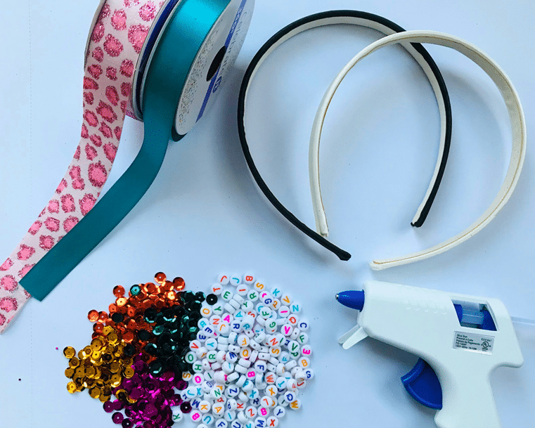 Project supplies: ribbon, beads, glue gun and hair accessory base.