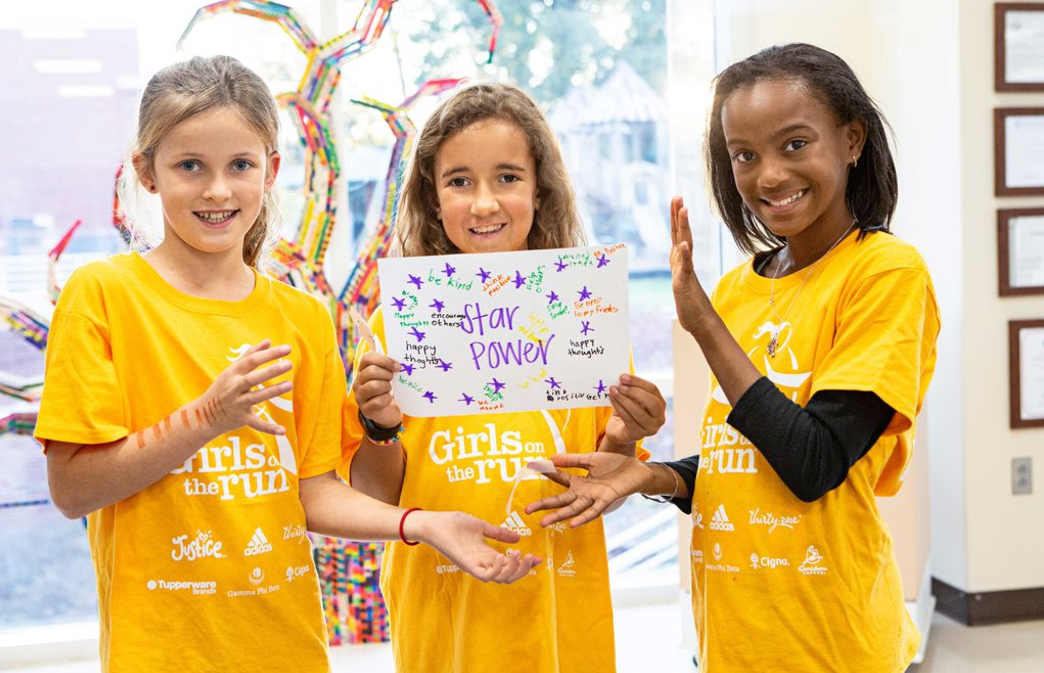 Three GOTR girls in yellow shirts holding a hand-made starpower sign.