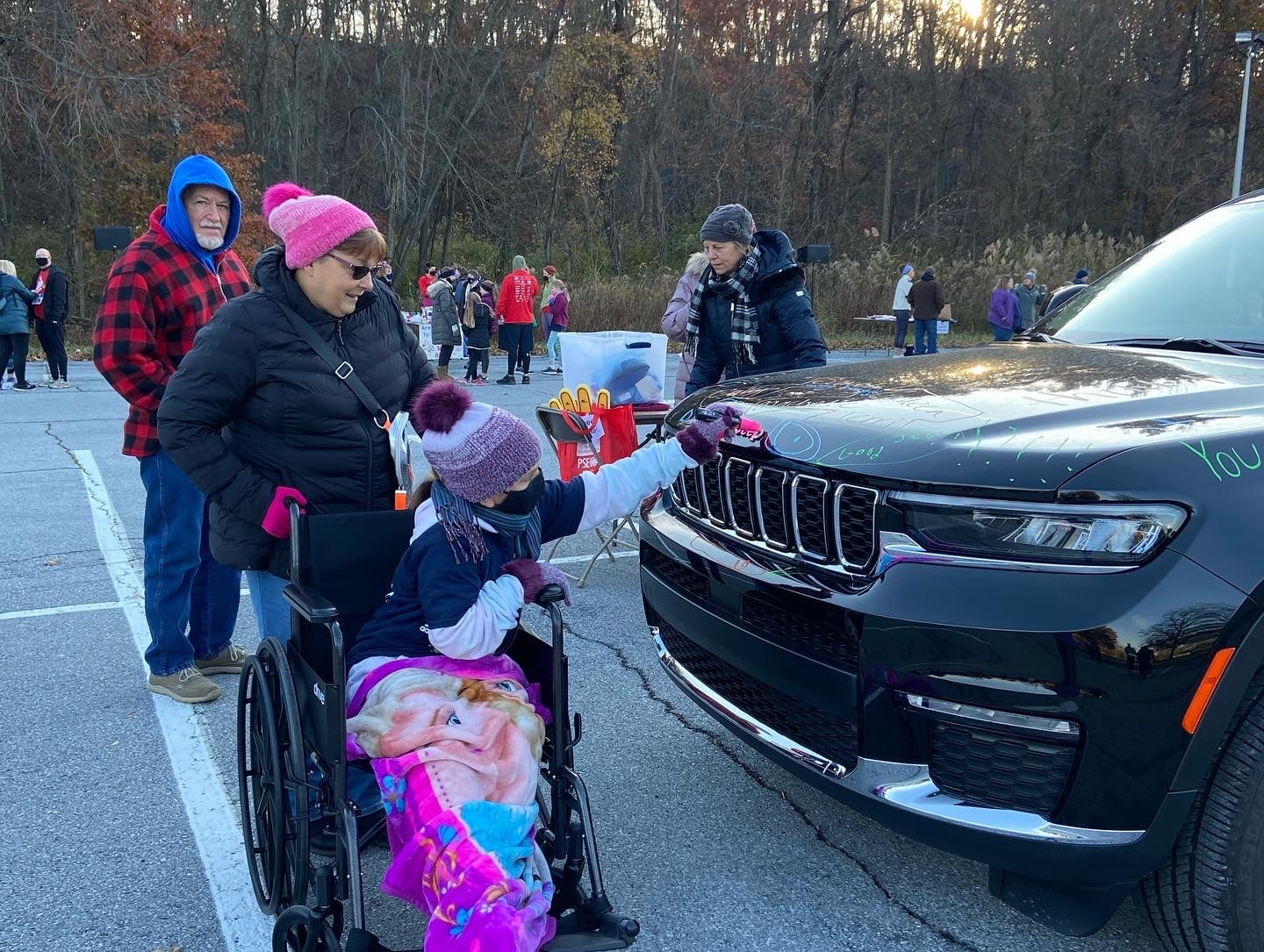 Mother and girl in wheelchair signing jeep is their fantastic 5K sign