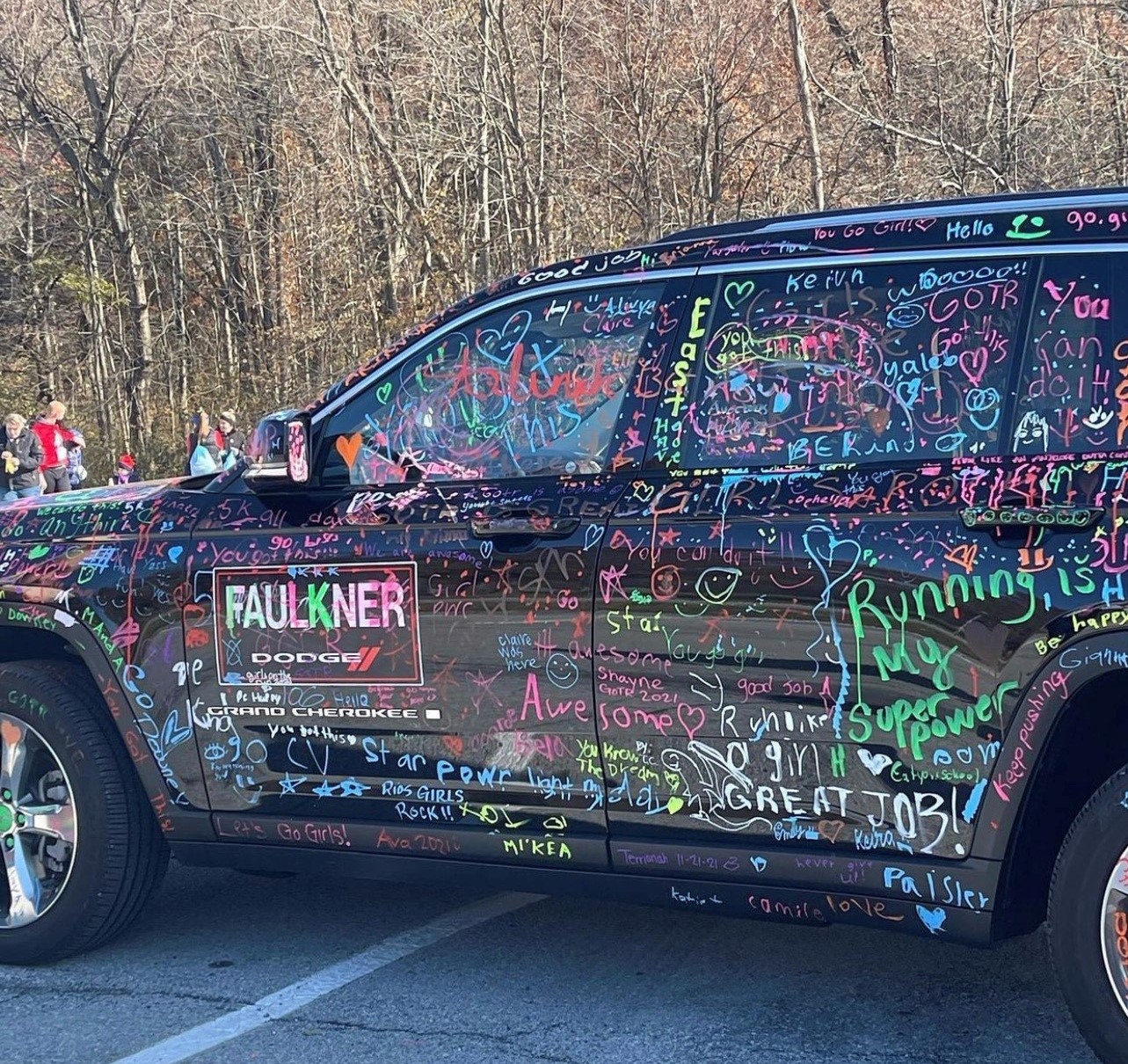 A black jeep is covered with colorful signatures from girls on the run participants and coaches makes for fantastic 5K sign