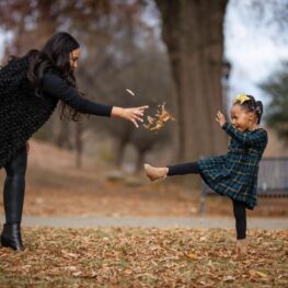 Michelle and Ava playing in leaves for Black History Month