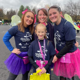 three coaches and one girl smiling at event