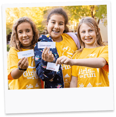 Three girls holding up inspirational words